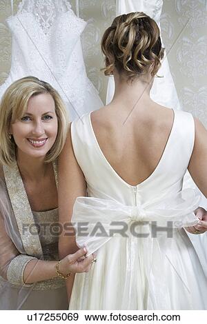 Stock Photo - Mother helping daughter to dress. Fotosearch