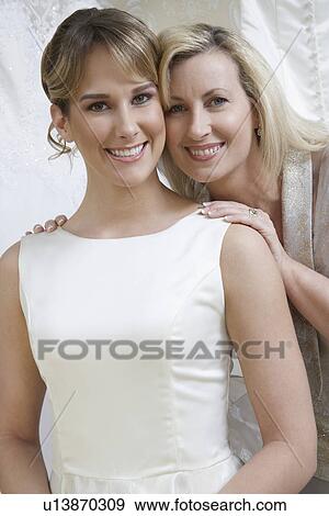 Mother touching daughter in wedding dress, portrait View Large Photo Image Stock Photo - Mother touching daughter in wedding dress, portrait. Fotosearch