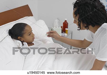 Nurse taking temperature of girl (7-9) lying in bed View Large Photo Image Stock Photography - Nurse taking temperature of girl (7-9) lying in bed. Fotosearch