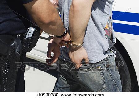 Stock Image - Officer Arresting Young Man. Fotosearch