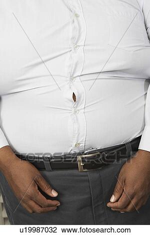 Overweight man wearing tight shirt, mid section View Large Photo Image Stock Image - Overweight man wearing tight shirt, mid section. Fotosearch