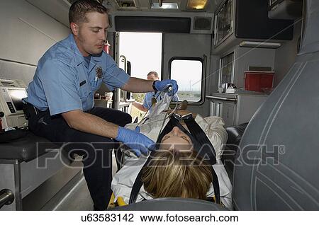 Paramedic taking care of victim in ambulance View Large Photo Image Stock Image - Paramedic taking care of victim in ambulance. Fotosearch