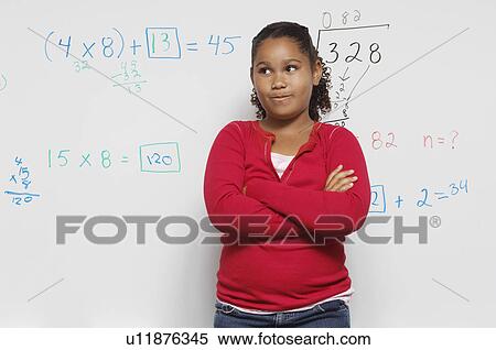 Stock Photography - Pensive Schoolgirl against whiteboard. Fotosearch