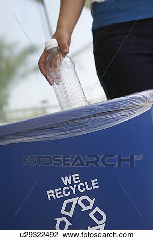 Stock Image - Person recycling plastic bottle, close-up. Fotosearch