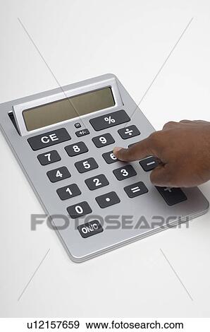 Stock Photo - Person using calculator, close-up of finger. Fotosearch