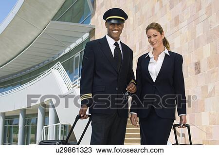 Pilot and flight attendant walking outside building View Large Photo Image Stock Image - Pilot and flight attendant walking outside building. Fotosearch