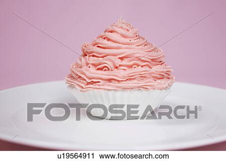 Stock Image - Pink cupcake on plate. Fotosearch