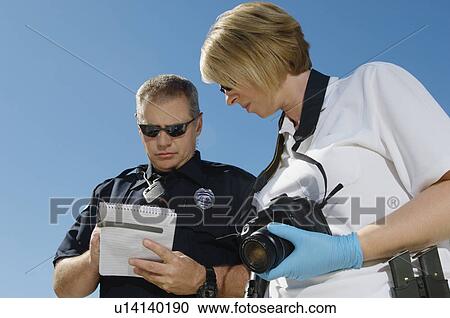 Stock Image - Police Officer and Investigator with Camera. Fotosearch
