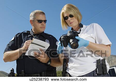 Stock Image - Police Officer and Investigator with Camera. Fotosearch