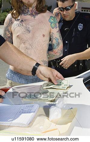 Stock Image - Police Officer Arresting Young Man. Fotosearch