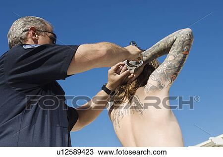 Stock Image - Police Officer Arresting Young Man. Fotosearch