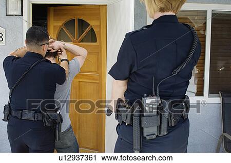 Stock Image - Police Officer Arresting Young Man. Fotosearch