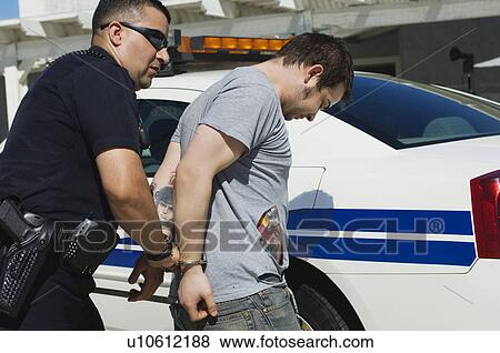 Stock Photo - Police Officer Arresting Young Man. Fotosearch