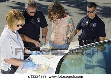 Stock Photo - Police Officer Arresting Young Man. Fotosearch