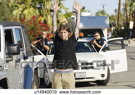 Stock Photo - Police Officer Arresting Young Man. Fotosearch