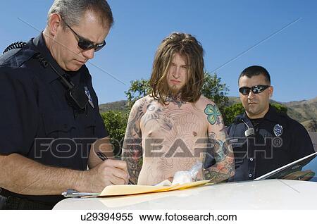 Stock Photography - Police Officer Arresting Young Man. Fotosearch