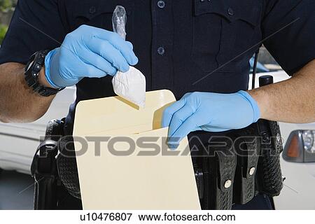 Stock Photo - Police Officer Putting Cocaine in Evidence Envelope. Fotosearch