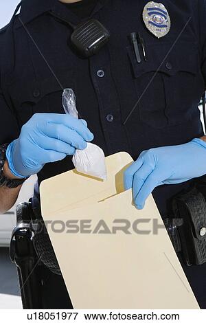 Stock Photo - Police Officer Putting Cocaine in Evidence Envelope. Fotosearch