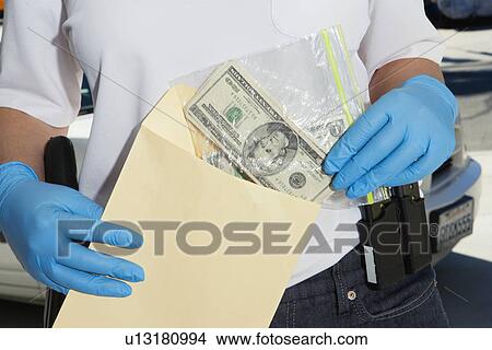 Police Officer Putting Money in Evidence Envelope View Large Photo Image Picture - Police Officer Putting Money in Evidence Envelope. Fotosearch
