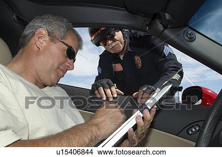 Picture - Police officer watching driver signing papers, view from car. Fotosearch