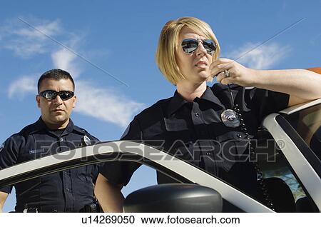 Stock Image - Police Officers Using Two-Way Radio. Fotosearch