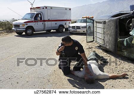 Policeman checking pulse of car crash victim View Large Photo Image Picture - Policeman checking pulse of car crash victim. Fotosearch