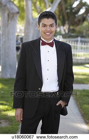 Stock Photo - Portrait of boy (13-15) in tuxedo at Quinceanera. Fotosearch