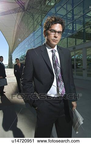 Stock Image - Portrait of businessman in front of office building. Fotosearch