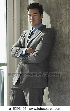 Stock Photography - Portrait of businessman leaning on wall. Fotosearch