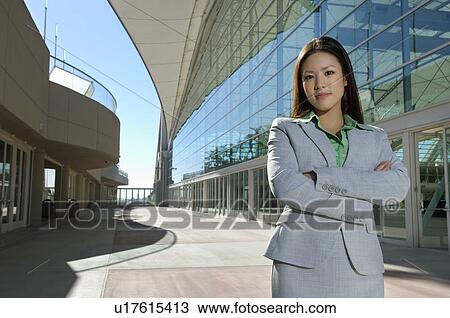 Stock Image - Portrait of businesswoman outside office building. Fotosearch
