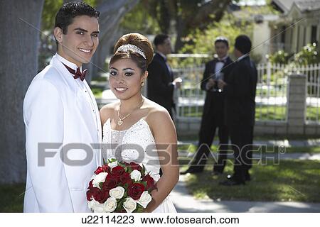 Stock Image - Portrait of couple (13-15) in garden at Quinceanera. Fotosearch
