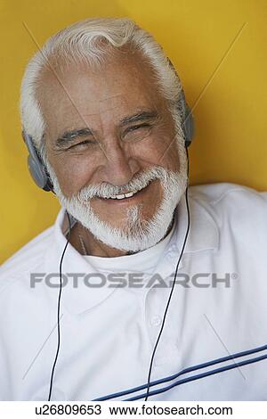 Stock Image - Portrait of elderly man wearing headphones. Fotosearch