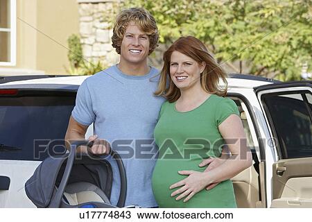 Portrait of expectant couple standing by car View Large Photo Image Stock Image - Portrait of expectant couple standing by car. Fotosearch