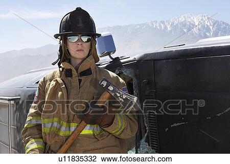 Portrait of female firefighter holding axe in mountains View Large Photo Image Stock Image - Portrait of female firefighter holding axe in mountains. Fotosearch