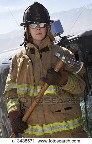 Portrait of female firefighter holding axe View Large Photo Image Stock Image - Portrait of female firefighter holding axe. Fotosearch