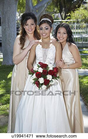 Stock Image - Portrait of girl (13-15) with friends in garden at Quinceanera. Fotosearch