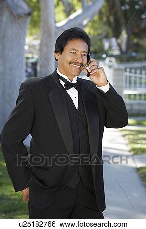 Portrait of man in tuxedo at Quinceanera, using mobile phone View Large Photo Image Stock Photograph - Portrait of man in tuxedo at Quinceanera, using mobile phone. Fotosearch