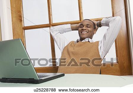 Portrait of mid adult business man at desk in front of laptop View Large Photo Image Stock Photo - Portrait of mid adult business man at desk in front of laptop. Fotosearch