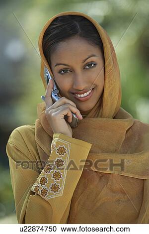 Stock Image - Portrait of muslim woman talking on mobile. Fotosearch