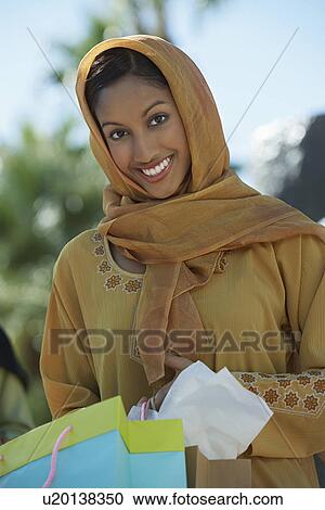 Stock Image - Portrait of muslim woman with shopping bag. Fotosearch