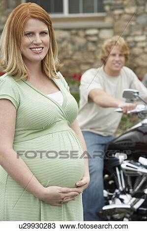 Portrait of pregnant woman, man on bike in background View Large Photo Image Stock Image - Portrait of pregnant woman, man on bike in background. Fotosearch