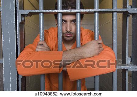 Stock Image - Portrait of prisoner behind bars. Fotosearch