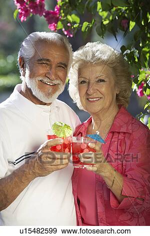 Stock Photo - Portrait of senior couple with drinks outdoors. Fotosearch