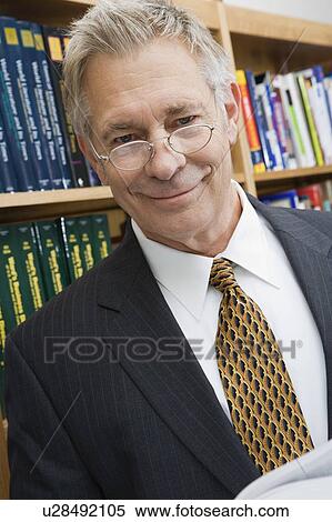 Stock Photography - portrait of senior man wearing suit in library. Fotosearch