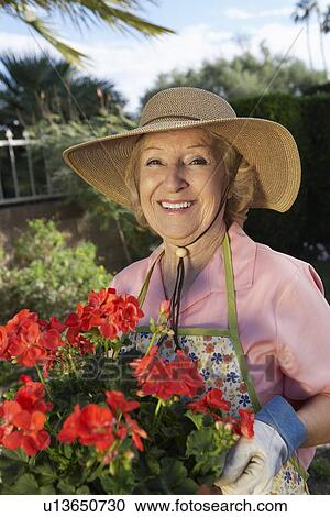 Portrait of senior woman with flowers in garden View Large Photo Image Stock Image - Portrait of senior woman with flowers in garden. Fotosearch