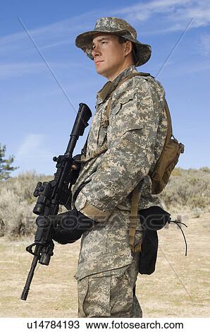 Stock Image - Portrait of soldier with machine gun. Fotosearch