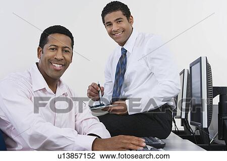 Stock Image - Portrait of two business men in office. Fotosearch