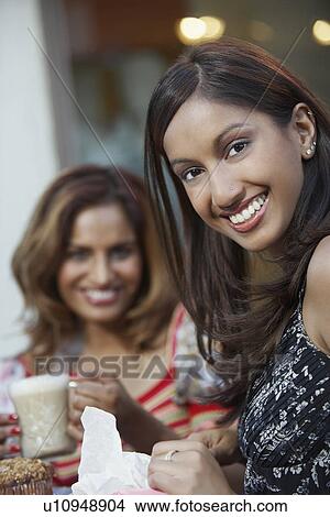 Picture - Portrait of two women at cafe table. Fotosearch