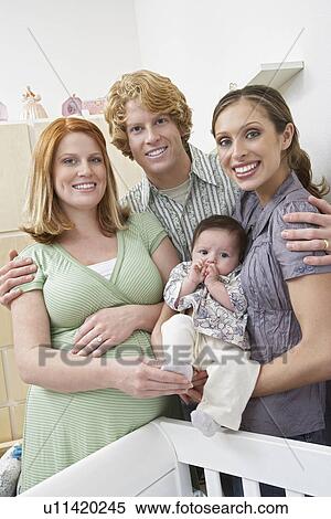 Portrait of two women, man and baby (1-6 months) in room View Large Photo Image Stock Photography - Portrait of two women, man and baby (1-6 months) in room. Fotosearch