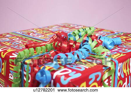 Stock Image - Present wrapped with colourful paper, close-up. Fotosearch